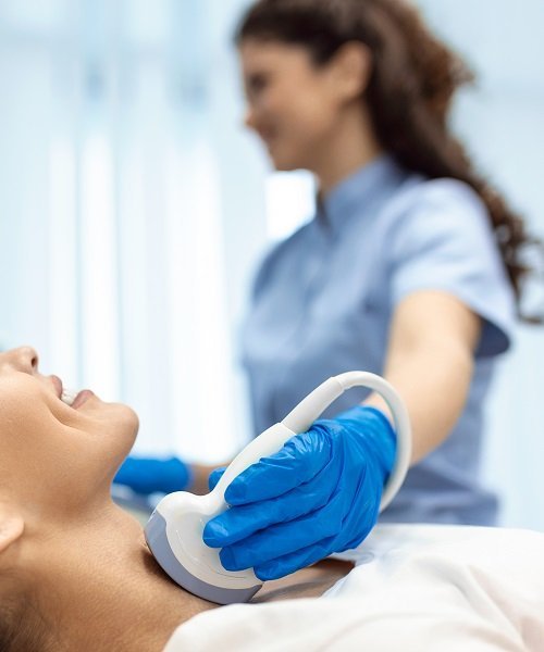 Ultrasound thyroid diagnostic scan being performed on a patient